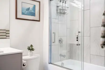 a bathroom with a shower with a glass door at Revytalise - Cozy 3 Bedroom Condo in Revelstoke