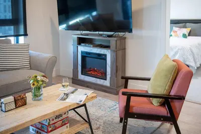 a living room with a fireplace and a tv at Revytalise - Cozy 3 Bedroom Condo in Revelstoke