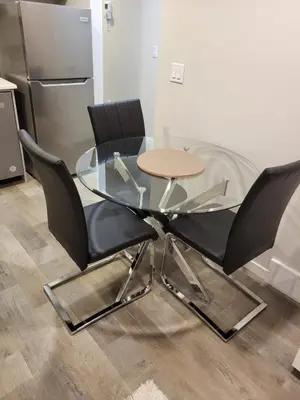 a glass table and two black chairs in a kitchen at Modern 2 Bed Urban Retreat in Calgary