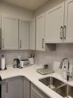 a kitchen with white cabinets and a sink at Modern 2 Bed Urban Retreat in Calgary