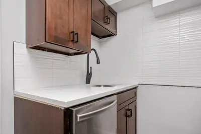 a kitchen with wooden cabinets and a sink at CenterStreet-Cozy 2bedroomSuite in Calgary