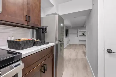 a kitchen with wooden cabinets and a refrigerator at CenterStreet-Cozy 2bedroomSuite in Calgary
