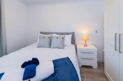 a bedroom with a large white bed with a blue blanket at NN - The Current 2 - Downtown 1-Bed 1-Bath in Whitehorse