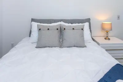 a bed with white sheets and pillows in a bedroom at NN - The Current 2 - Downtown 1-Bed 1-Bath in Whitehorse
