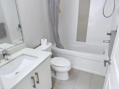 a white bathroom with a sink and a toilet and a tub at Spacious Home in Richmond in Richmond