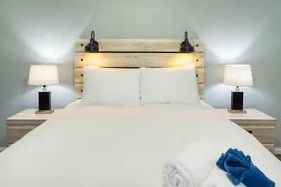 a bedroom with a large white bed with two lamps at NN - The Mack - Crestview 1-bed 1-bath in Whitehorse