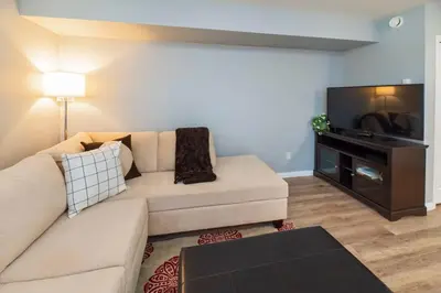 a living room with a couch and a flat screen tv at NN - The Mack - Crestview 1-bed 1-bath in Whitehorse
