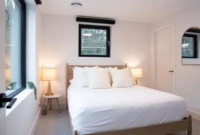 a bedroom with a white bed with white pillows at Powder Pines Retreat by Revelstoke Vacations in Revelstoke