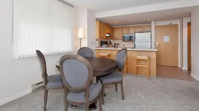 a kitchen and dining room with a table and chairs at Woodrun Lodge 517 | Large Ski-In Ski-Out Condo by Upper Village w/ Mountain Views & Shared Hot Tub in Whistler