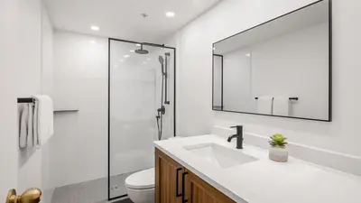 a bathroom with a sink and a toilet and a mirror at Woodrun Lodge 517 | Large Ski-In Ski-Out Condo by Upper Village w/ Mountain Views & Shared Hot Tub in Whistler
