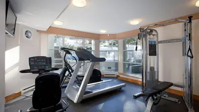 a room with a gym with a treadmill and a window at Woodrun Lodge 517 | Large Ski-In Ski-Out Condo by Upper Village w/ Mountain Views & Shared Hot Tub in Whistler