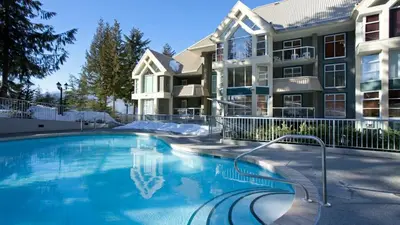 a swimming pool in front of a apartment building at Woodrun Lodge 517 | Large Ski-In Ski-Out Condo by Upper Village w/ Mountain Views & Shared Hot Tub in Whistler