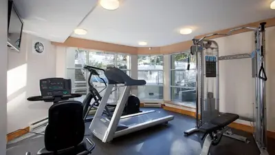 a room with a gym with a treadmill and a window at Woodrun Lodge 417 | Ski-In Ski-Out, Pool, Hot Tub, Free Parking in Whistler