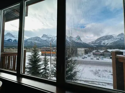 a view of a snowy mountain range from a window at Canmore Mountain Retreat - Heated Pool & Hot-tub in Canmore