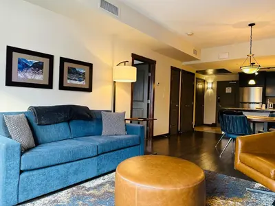 a living room with a blue couch and a table at Canmore Mountain Retreat - Heated Pool & Hot-tub in Canmore