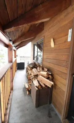a building with a bunch of wood on the wall at Romantic Off-Grid Cabin by Glacier lake in Pemberton