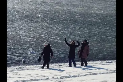 a group of people standing on top of the snow at Romantic Off-Grid Cabin by Glacier lake in Pemberton