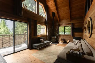 a living room with a bed and a fireplace at Romantic Off-Grid Cabin by Glacier lake in Pemberton