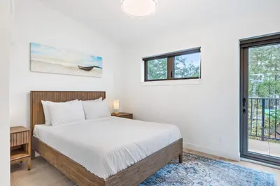 a bedroom with a bed and a window at Seas The Day Saratoga at THE BEACH HOUSE in Campbell River