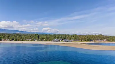 an aerial view of a beach with houses and trees at Seas The Day Saratoga at THE BEACH HOUSE in Campbell River