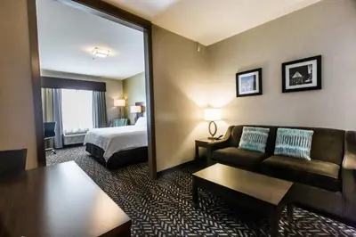 a hotel room with a bed and a couch at Holiday Inn Express & Suites Spruce Grove - Stony Plain by IHG in Spruce Grove