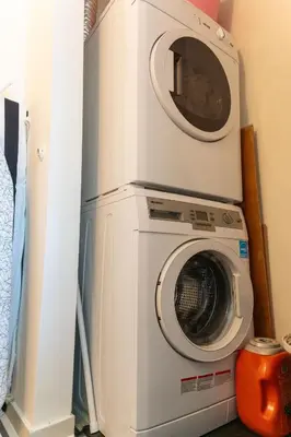 a washer and dryer in a room at Modern top-floor 1-bedroom loft with free parking in Vancouver