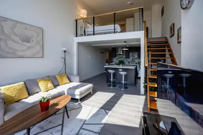 a living room with a couch and a kitchen at Modern top-floor 1-bedroom loft with free parking in Vancouver