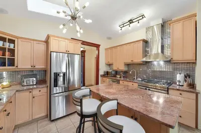 a kitchen with wooden cabinets and a granite counter top at Dolphin House by EMR Vacation Rentals in Nanoose Bay
