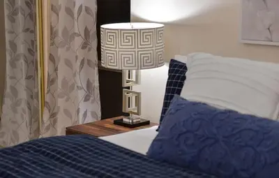 a lamp sitting on a night stand next to a bed at Dolphin House by EMR Vacation Rentals in Nanoose Bay