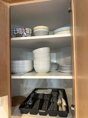 a cabinet filled with plates and bowls and dishes at W400 Mountain Surround Top Floor Canmore Vacation in Canmore