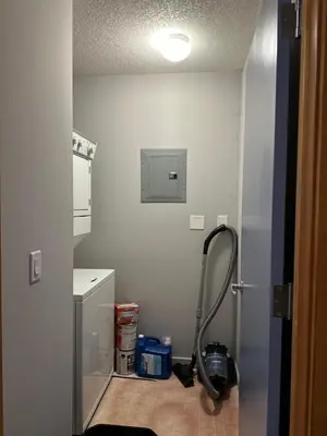 a small kitchen with a refrigerator and a vacuum at W400 Mountain Surround Top Floor Canmore Vacation in Canmore