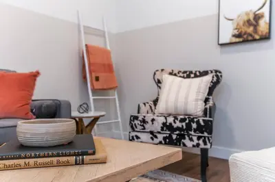 a living room with a chair and a table at Modern Country Retreat-5 min to DTN-U/G Parking in Edmonton