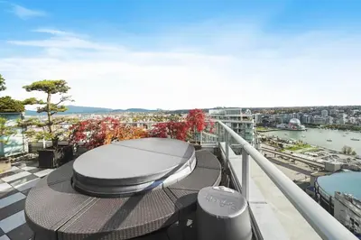 a balcony with a table and a view of a city at Skyline Hideaway in Vancouver