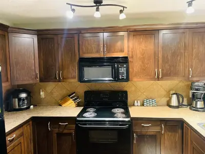 a kitchen with wooden cabinets and a black stove top oven at Summit View Alpine Retreat in Radium Hot Springs