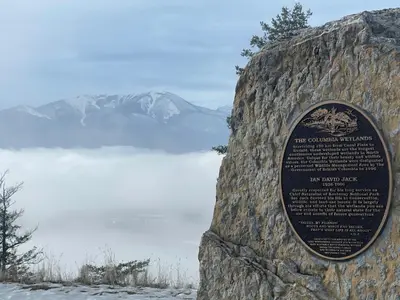 a rock wall with a sign on it next to a lake at Summit View Alpine Retreat in Radium Hot Springs