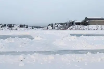 a snow covered rink with people in the background at Yellowknife Downtown 50a avenue Retreat in Yellowknife