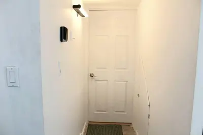 a hallway with a white door and a spotlight at Yellowknife Downtown 50a avenue Retreat in Yellowknife