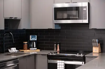 a kitchen with a stove and a microwave at Villa 23 Cabot Peaks by Revelstoke Vacations in Revelstoke
