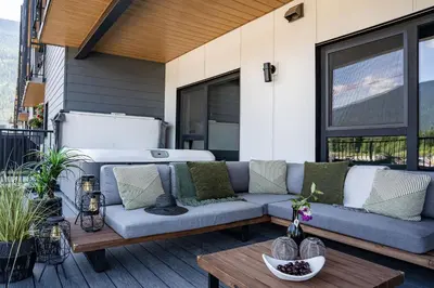 a patio with a couch and a table on a balcony at Villa 23 Cabot Peaks by Revelstoke Vacations in Revelstoke