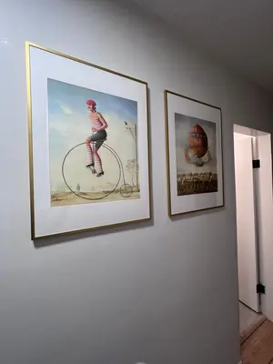 two framed pictures of a woman riding a bike on a wall at Good Old Days Main Retro in Vancouver