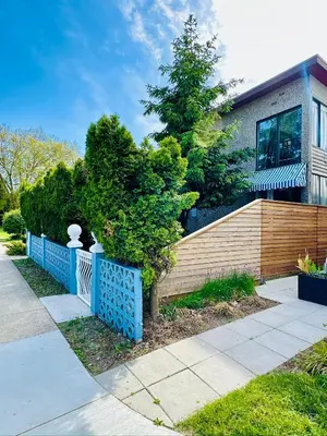 a house with a blue fence in front of it at Good Old Days Main Retro in Vancouver