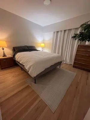 a bedroom with a bed and a dresser with two lamps at Good Old Days Main Retro in Vancouver