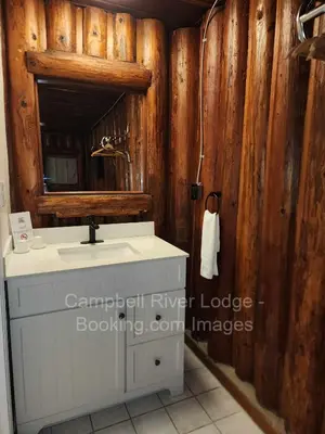 a bathroom with a sink and a mirror at Campbell River Lodge in Campbell River