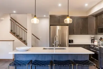 a kitchen with a large island with blue stools at Polar Peak Lodges by Fernie Central Reservations in Fernie