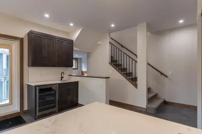 an empty kitchen with a sink and a staircase at Polar Peak Lodges by Fernie Central Reservations in Fernie