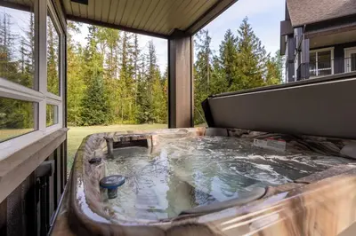 a hot tub on the back of a house at Polar Peak Lodges by Fernie Central Reservations in Fernie