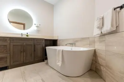 a bathroom with a white tub and a mirror at Polar Peak Lodges by Fernie Central Reservations in Fernie