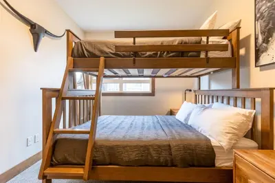 two bunk beds in a room with a bed at Polar Peak Lodges by Fernie Central Reservations in Fernie