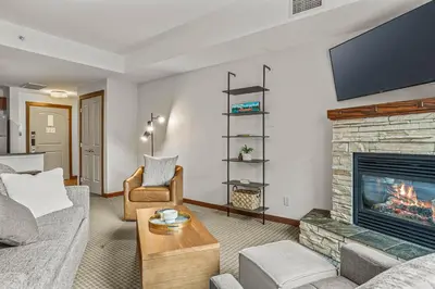a living room with a couch and a fireplace at Romantic Mountain Escape - Hot Tubs & Private Balcony! managed by Little Sister Getaways in Canmore