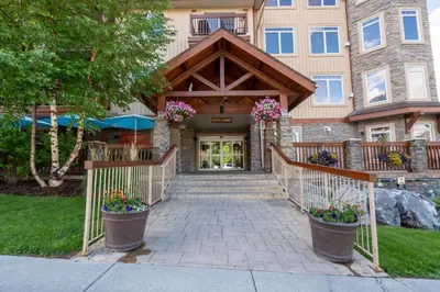 a home with a stone entrance with flowers in pots at Romantic Mountain Escape - Hot Tubs & Private Balcony! managed by Little Sister Getaways in Canmore